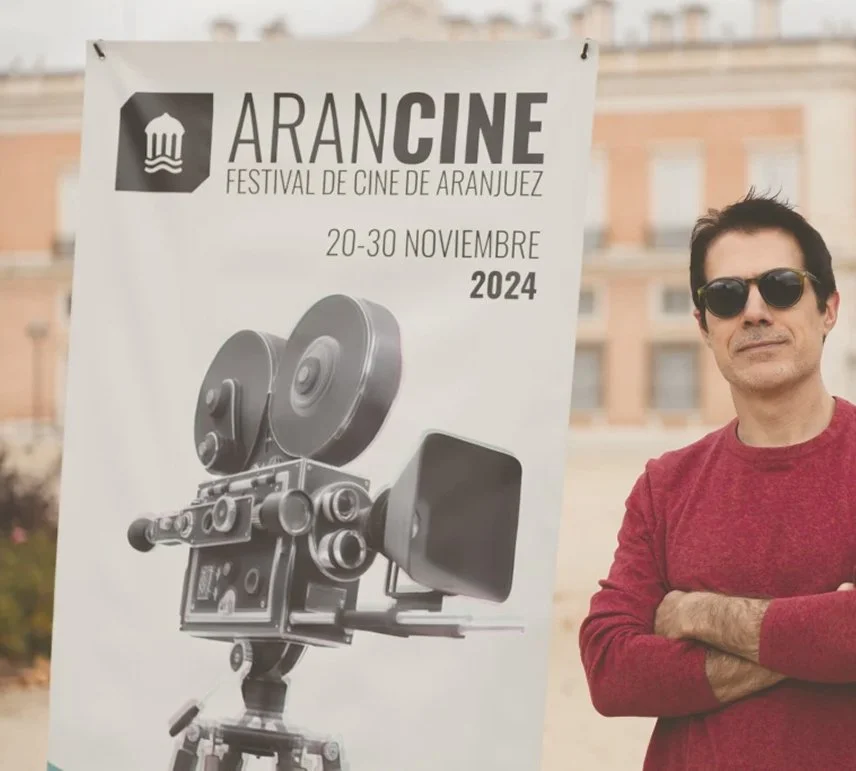 Attendee next to the festival poster